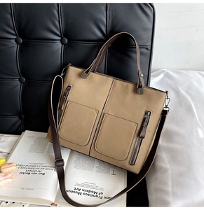 Detail of khaki frosted leather tote bag with double front pockets and brown handles