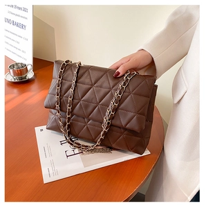 Détail du sac à bandoulière matelassé en similicuir marron avec chaîne dorée