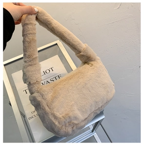 Détail du sac à main en peluche crème avec texture douce et fermeture éclair dorée