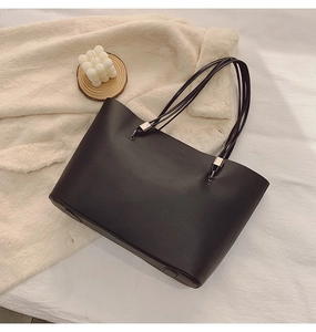 Détail d'un sac cabas en cuir noir avec embossage FASHION et finitions métalliques argentées