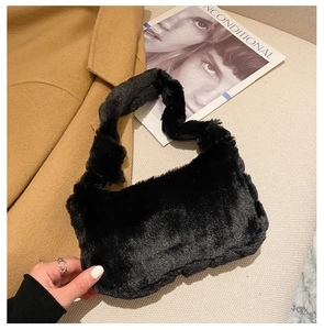 Texture détaillée du sac sous le bras en peluche noire avec bandoulière large et douce