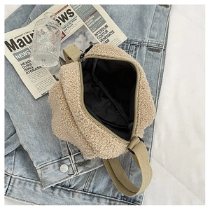 Vue détaillée du sac à bandoulière en laine beige avec sangle sur veste en jean