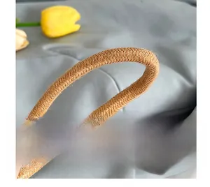 Gros plan sur la bandoulière tressée marron d'un sac seau d'été avec détails floraux