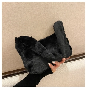 Gros plan sur la texture d'un sac à main noir en fausse fourrure douce et pelucheuse