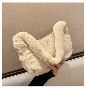 Gros plan d'un sac à main en peluche beige doux montrant la texture luxueuse et la poignée