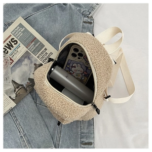 Gros plan du mini sac à dos en polaire beige montrant sa capacité de rangement interne