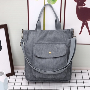 Minimalist grey corduroy tote bag with front snap pocket and adjustable strap