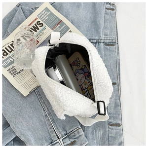 Vue intérieure d'un sac bandoulière en laine d'agneau blanche avec portable et gourde