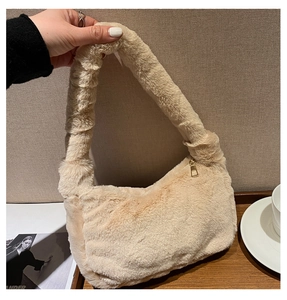 Détail d'un sac à main beige en fausse fourrure montrant sa texture douce et sa anse