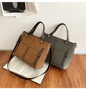 Close-up of matte suede tote bags with double front pockets on a wooden desk