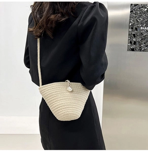 Détail du sac seau tressé avec fermoir perle et fine bandoulière porté par le mannequin
