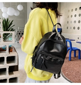 Modern black pebbled leather mini backpack featuring stylish fringe tassel zippers