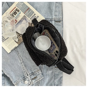 Détail de l'intérieur spacieux du sac bandoulière en peluche noire sur du denim