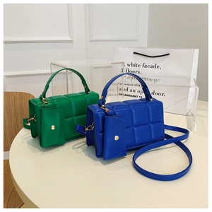 Dettaglio della borsa shopper trapuntata verde e blu con portamonete rotondo e dettagli dorati