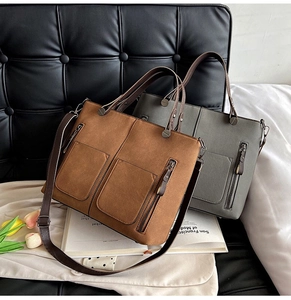 Close-up of matte leather tote bags in brown and grey with dual front pockets and metal zippers