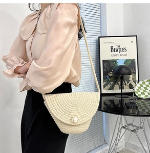 Cream straw woven shoulder bag with large pearl buckle for summer beach vacations