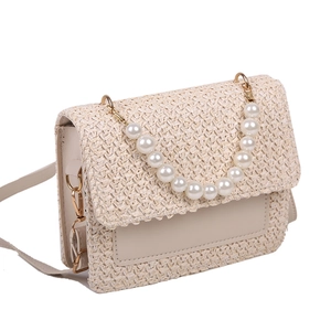 Cream woven straw crossbody bag with elegant pearl top handle and gold hardware detail