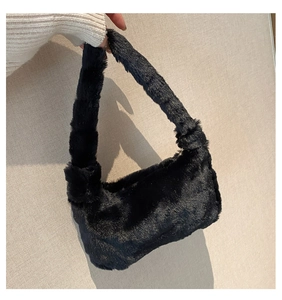 Détail d'un sac à bandoulière en fausse fourrure noire douce avec large poignée peluche