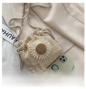 Macro shot of hand-woven straw bucket bag with white sunflower and drawstring