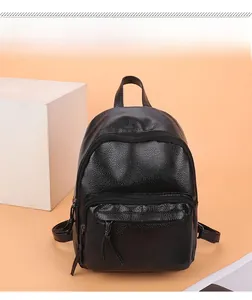 Detail of black lychee grain leather backpack with zip pockets and top handle
