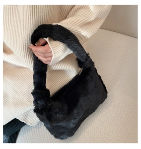 Détail de la texture d'un sac à main noir en fausse fourrure avec poignée douce