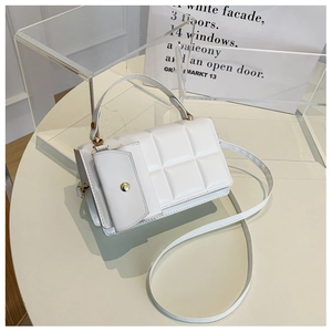 Dettaglio borsa a tracolla trapuntata bianca con chiusura dorata e piccolo borsellino