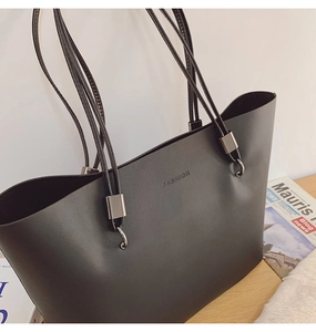 Détail d'un sac cabas en cuir noir mat avec logo FASHION en relief métallique