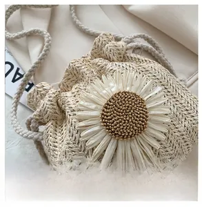 Detail of hand-woven beige straw bucket bag featuring a large 3D daisy flower design