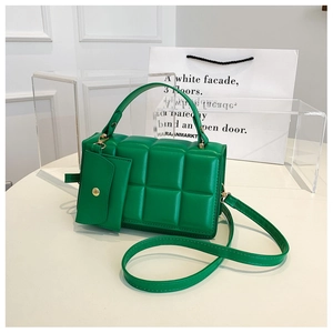 Dettaglio borsa trapuntata verde con portamonete coordinato e finiture dorate