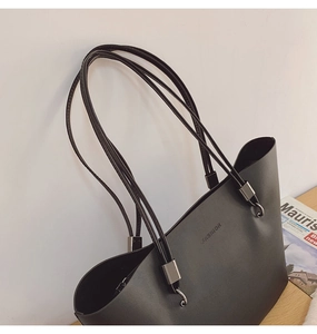 Détail du sac cabas en similicuir noir avec fines bandoulières et boucle en argent
