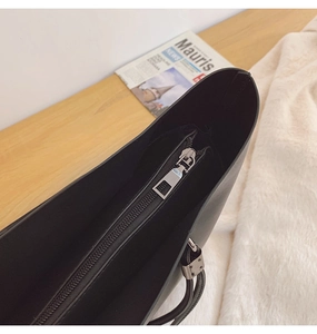 Détail de la fermeture éclair et du compartiment interne d'un sac cabas en cuir noir