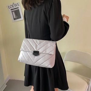 Chic quilted chain bag in pearl beige with V-stitch pattern and black metal clasp