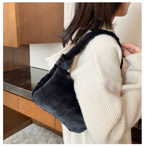 Gros plan du sac à bandoulière en peluche noire en fausse fourrure et tricot