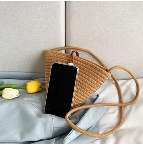 Détail d'un sac seau en paille tressé main avec fermeture aimantée et bandoulière corde