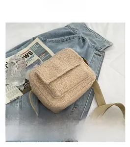 Détail du sac bandoulière beige en laine d'agneau avec sangle kaki sur veste denim