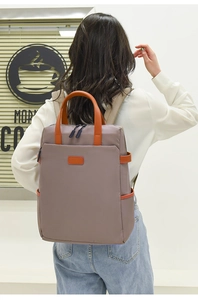 Detailansicht des grau-braunen wasserfesten Laptop-Rucksacks mit orangefarbenem Lederakzent