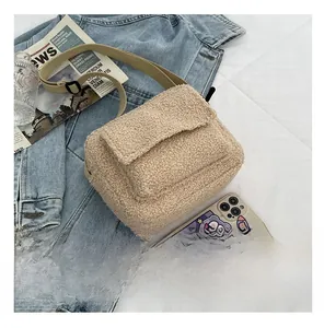 Vue détaillée du sac à rabat en sherpa beige avec bandoulière sur veste en jean