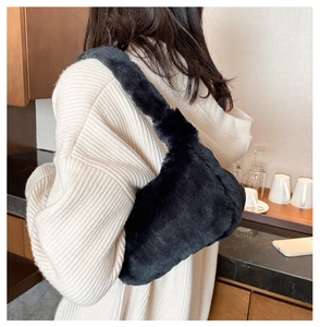 Détails de la texture du sac à bandoulière en fausse fourrure noire porté en tenue décontractée