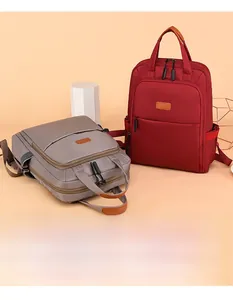 Detail view of burgundy and grey waterproof oxford backpacks with reinforced handles