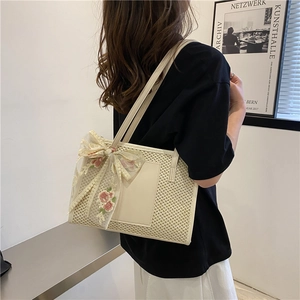 Sac fourre-tout tissé crème chic avec nœud en dentelle florale porté à l'épaule