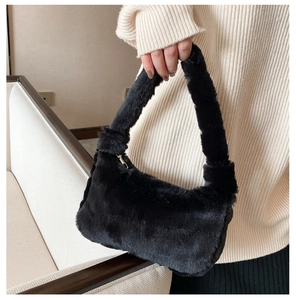 Détail du sac sous le bras en peluche noire avec fermeture éclair dorée chic
