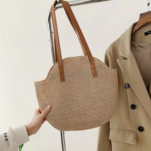 Straw woven tote bag with brown leather straps for beach holidays and casual summer style