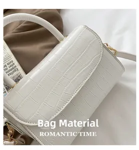 Detailed close-up of white crocodile pattern leather texture with gold metal hardware hooks