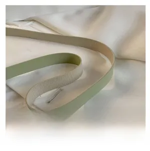 Close-up of light green shoulder strap showing smooth texture and woven anti-slip lining