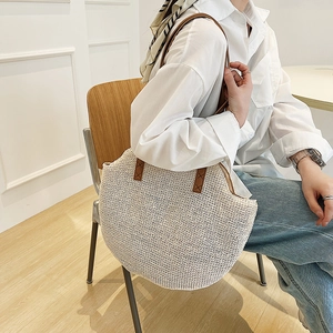Retro large beige woven straw shoulder bag with brown leather handles for beach vacation