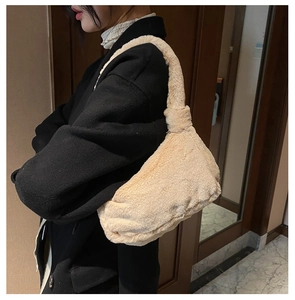 Vue latérale du sac à bandoulière en peluche beige sur modèle soulignant sa texture douce