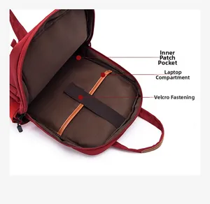 Detail of red backpack interior with brown lining, laptop compartment, and velcro strap
