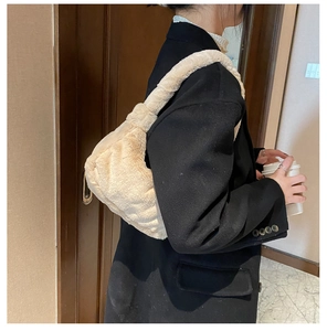 Détail d'un sac à épaule en peluche crème avec texture plissée douce et bandoulière