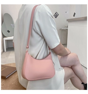 Pink matte PU leather hobo bag worn on shoulder with golden hardware details