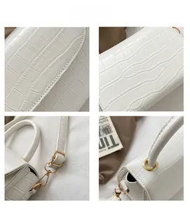 Close-up of white crocodile pattern texture with polished gold hardware on hand bag